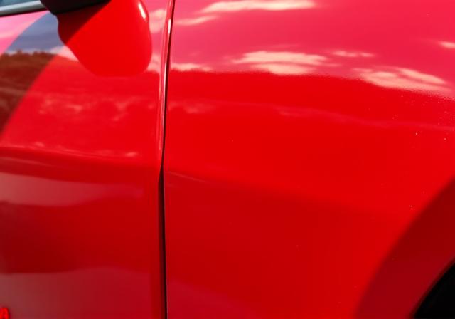 The same red paintwork, now glossy and reflective after polishing.